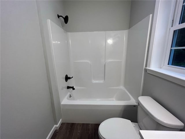 bathroom featuring hardwood / wood-style floors, toilet, and shower / washtub combination