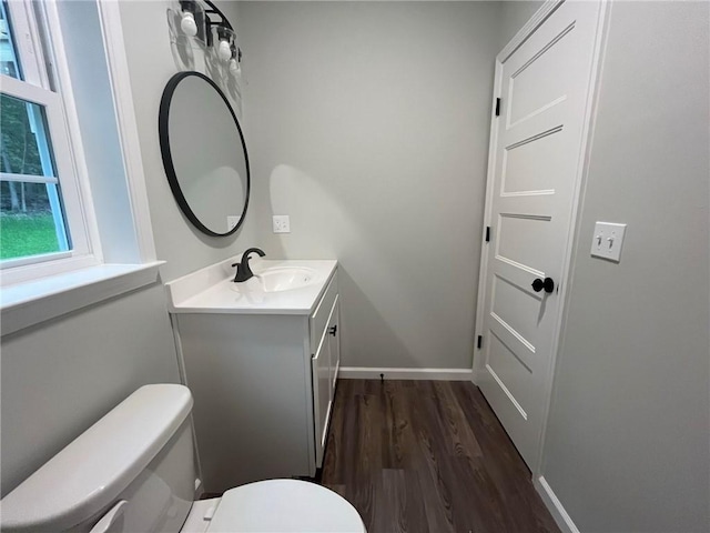 bathroom with hardwood / wood-style floors, vanity, and toilet