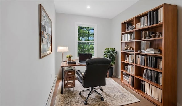 home office featuring hardwood / wood-style floors and a baseboard radiator