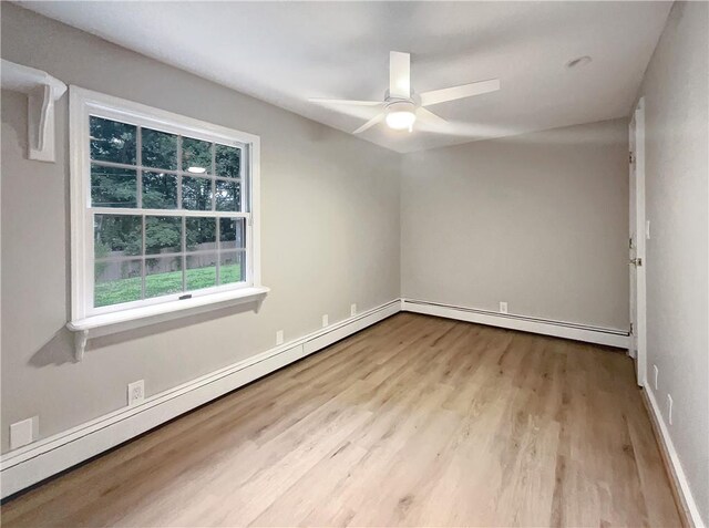 unfurnished room with ceiling fan, a baseboard heating unit, and light wood-type flooring