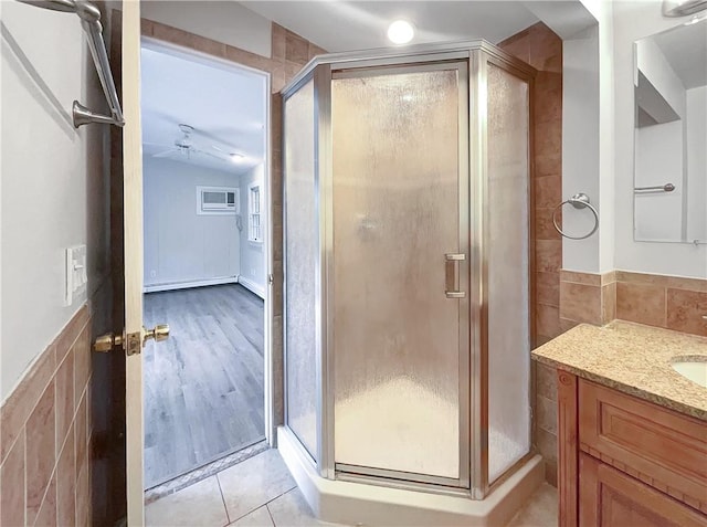 bathroom featuring hardwood / wood-style floors, vaulted ceiling, tile walls, and ceiling fan