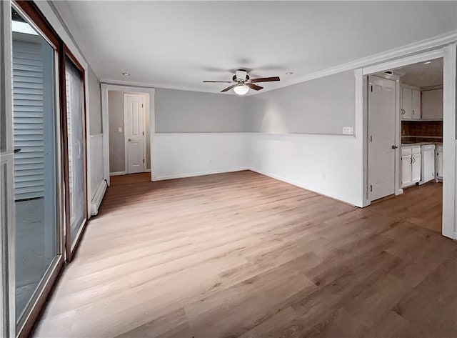 interior space featuring ceiling fan, light hardwood / wood-style floors, baseboard heating, and crown molding