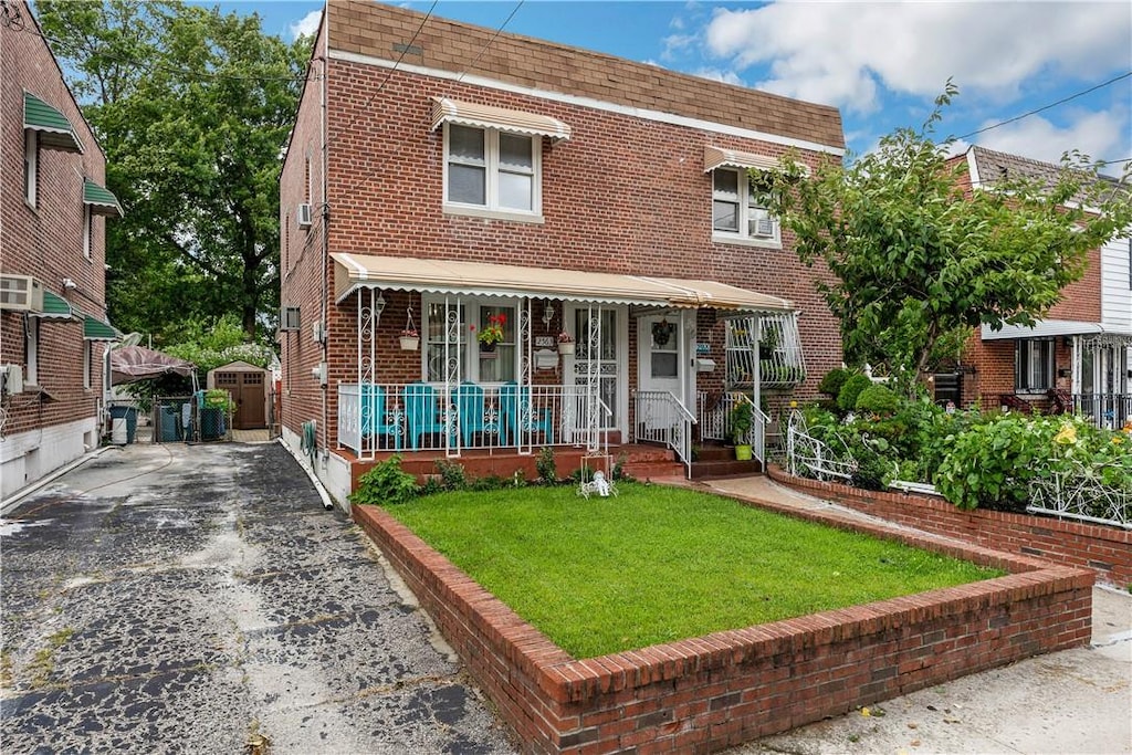 2563 Woodhull Ave, Bronx, NY 10469 - view of front of house with covered porch and a front lawn