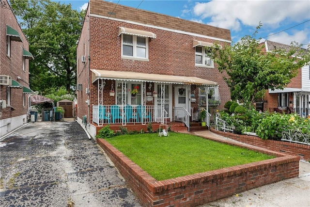 2563 Woodhull Ave, Bronx, NY 10469 - view of front of house with covered porch and a front lawn