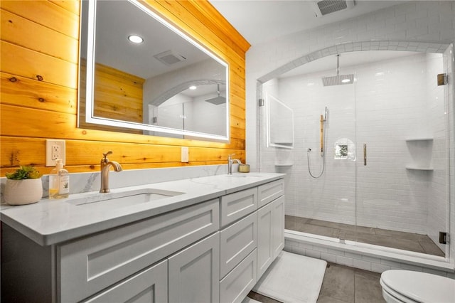 bathroom with tile patterned flooring, vanity, an enclosed shower, and wooden walls