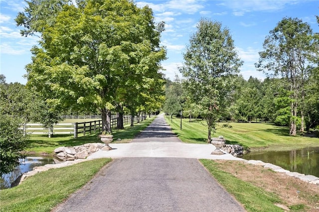 view of home's community with a water view and a lawn