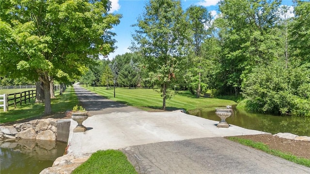 view of property's community with a lawn and a water view