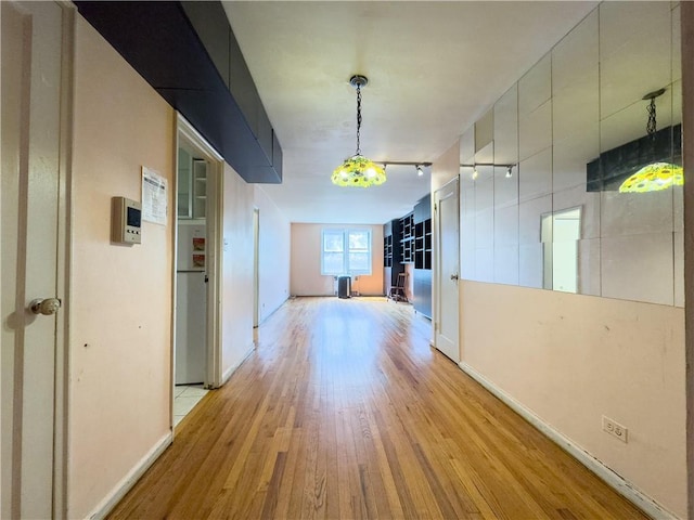 hallway with light hardwood / wood-style floors