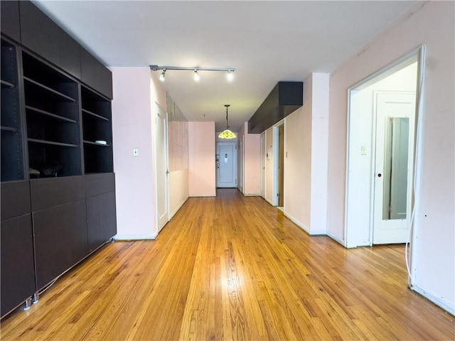 unfurnished room featuring track lighting and light hardwood / wood-style flooring