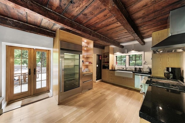 kitchen with plenty of natural light, french doors, stainless steel dishwasher, and wall chimney range hood