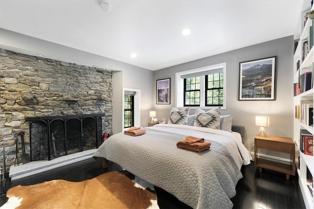 bedroom featuring a fireplace and dark hardwood / wood-style flooring