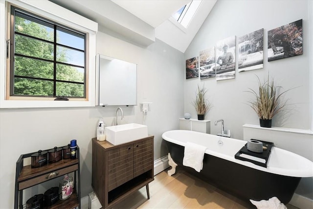 bathroom featuring vanity, a bathing tub, vaulted ceiling with skylight, a baseboard radiator, and wood-type flooring