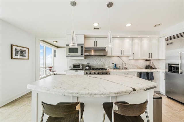 kitchen featuring decorative backsplash, ventilation hood, pendant lighting, built in appliances, and white cabinetry