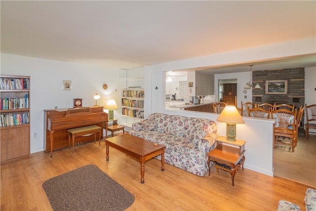 living room featuring light hardwood / wood-style flooring and a stone fireplace