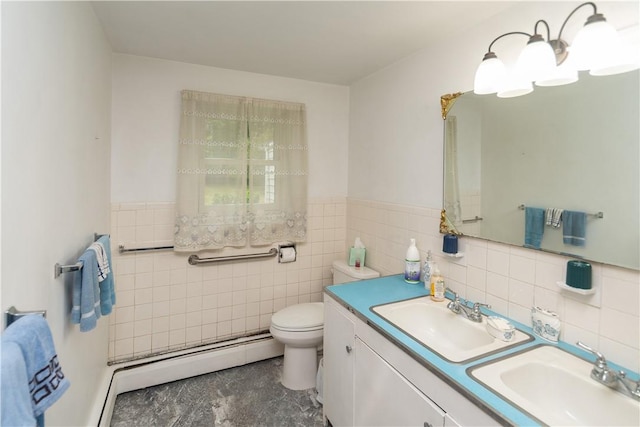 bathroom with vanity, toilet, baseboard heating, and tile walls