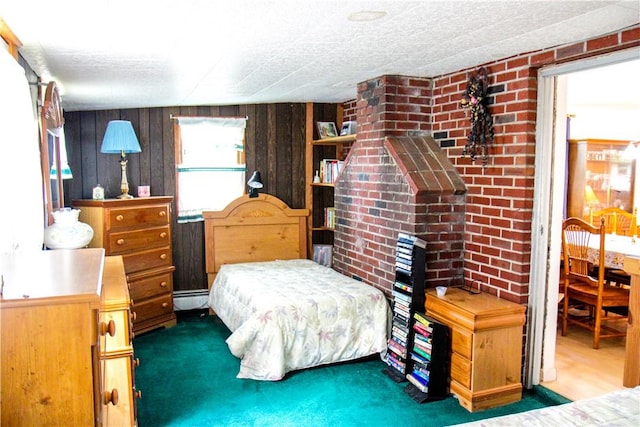 bedroom with wood walls, a textured ceiling, dark carpet, and a baseboard radiator