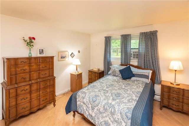 bedroom with light hardwood / wood-style flooring and baseboard heating