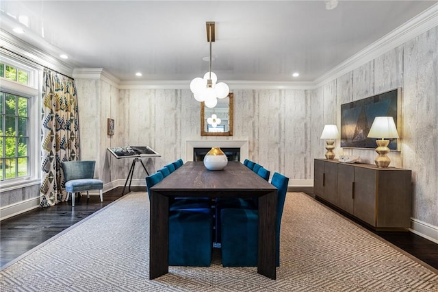 dining space with dark hardwood / wood-style flooring, ornamental molding, and a notable chandelier