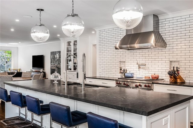 kitchen featuring white cabinetry, wall chimney exhaust hood, decorative light fixtures, and high end stainless steel range oven