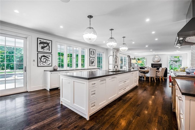 kitchen featuring pendant lighting, a center island with sink, plenty of natural light, and sink