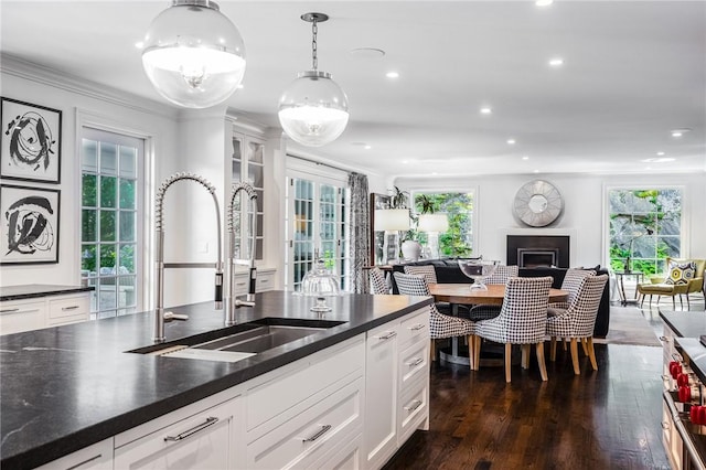 kitchen featuring pendant lighting, dark hardwood / wood-style flooring, white cabinetry, and sink