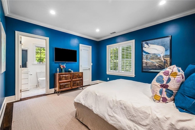 bedroom featuring light wood-type flooring, ornamental molding, and connected bathroom