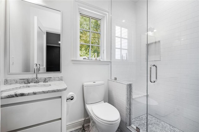 bathroom featuring vanity, an enclosed shower, and toilet