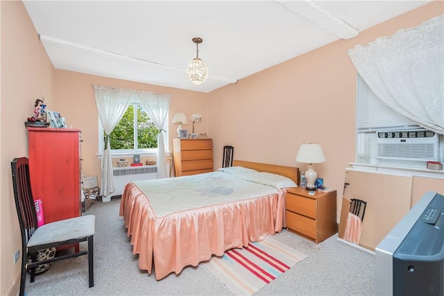 carpeted bedroom with beamed ceiling, radiator, and cooling unit