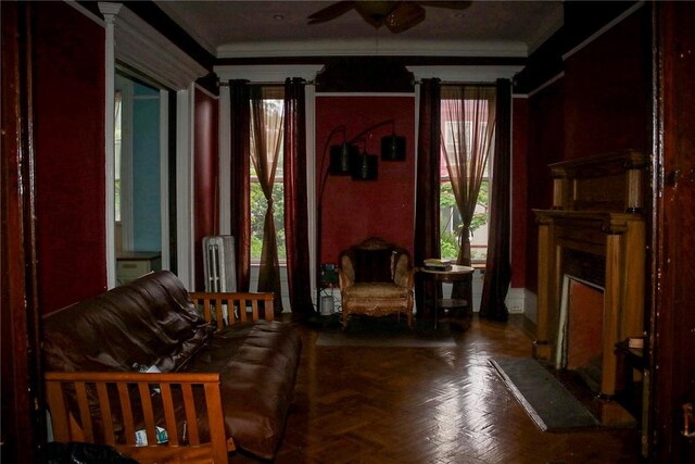 living area featuring ceiling fan, crown molding, parquet floors, and radiator heating unit