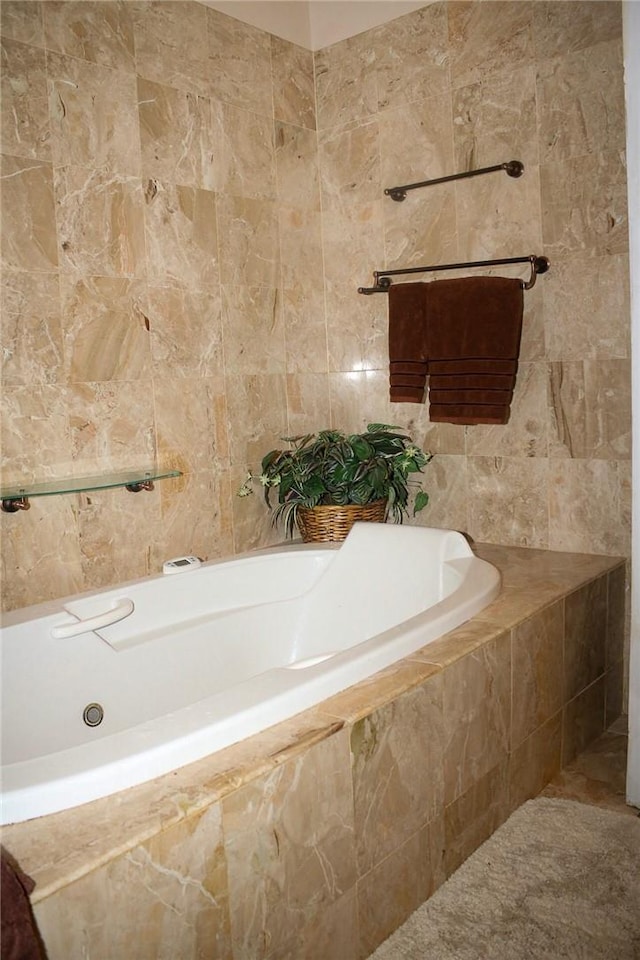 bathroom featuring tiled tub and tile walls