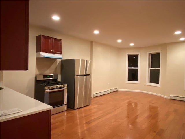 kitchen with stainless steel appliances, light wood-type flooring, and a baseboard heating unit