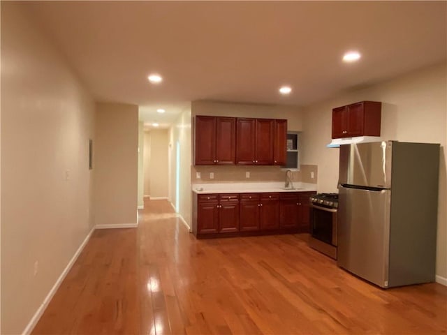 kitchen with sink, stainless steel appliances, and light wood-type flooring