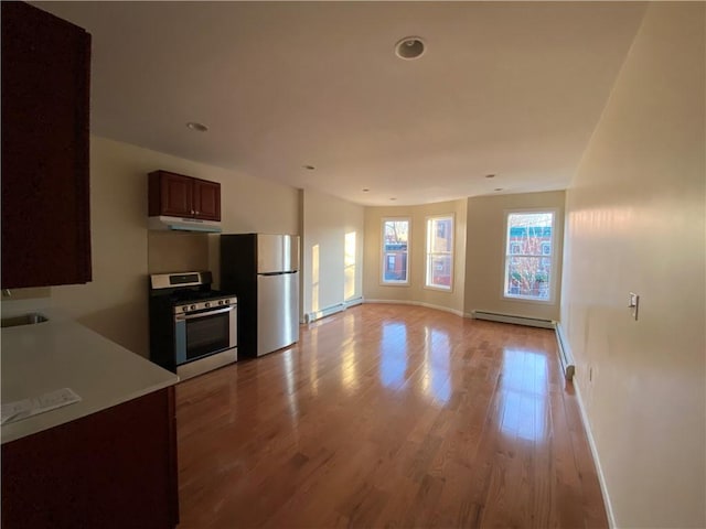 kitchen with light hardwood / wood-style floors, stainless steel appliances, and a baseboard radiator