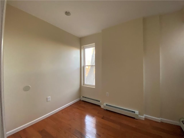 spare room featuring hardwood / wood-style floors and a baseboard radiator