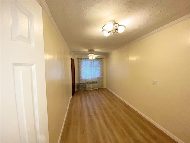 hallway with crown molding, hardwood / wood-style floors, and a textured ceiling