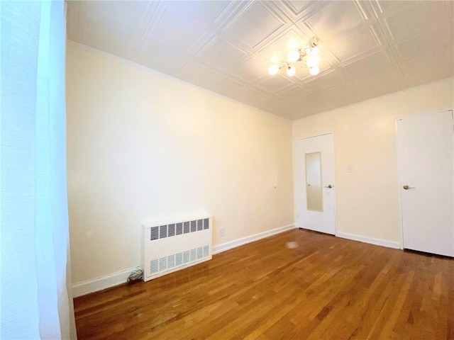 unfurnished room with hardwood / wood-style flooring and radiator