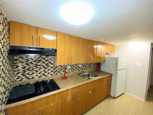 kitchen featuring backsplash, extractor fan, sink, white refrigerator, and black gas cooktop