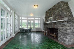 unfurnished sunroom featuring a fireplace and french doors