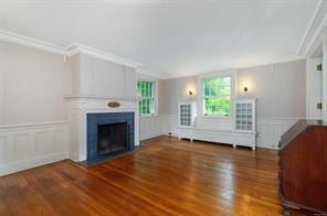 unfurnished living room featuring dark hardwood / wood-style floors and ornamental molding