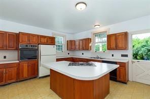 kitchen featuring stainless steel appliances, a kitchen island, and a healthy amount of sunlight