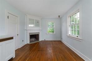 unfurnished living room with dark hardwood / wood-style floors and a healthy amount of sunlight