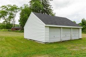 view of outdoor structure with a garage and a lawn