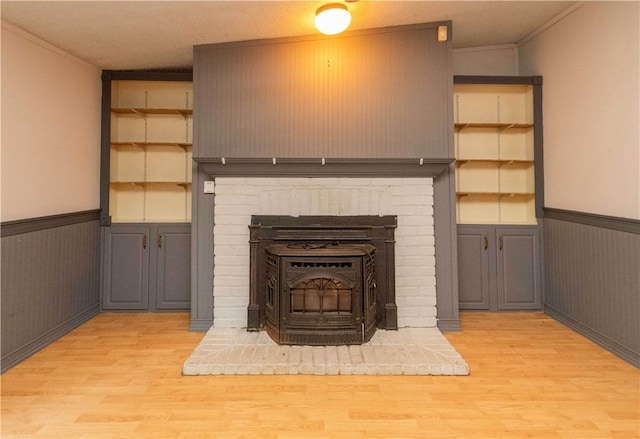 details with hardwood / wood-style flooring, a wood stove, ornamental molding, and wood walls