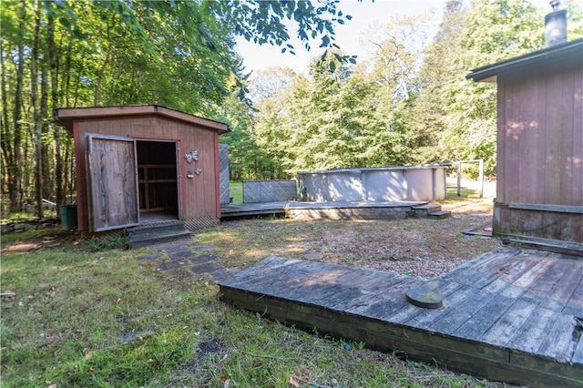 view of yard featuring a swimming pool side deck and a storage shed