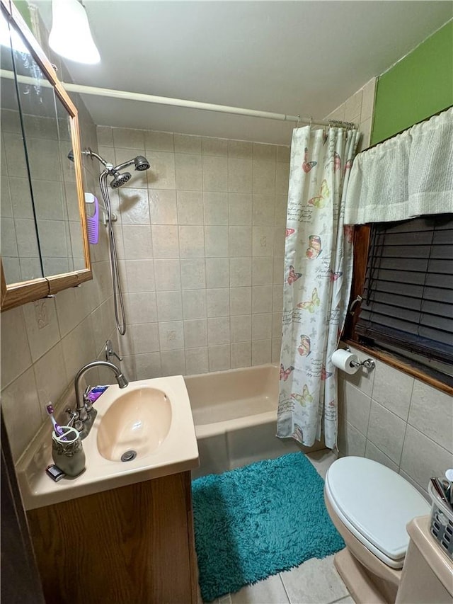 full bathroom featuring tile patterned flooring, vanity, tile walls, and toilet