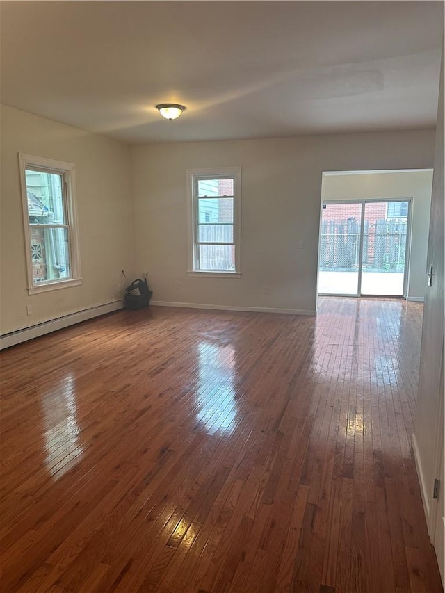 unfurnished room featuring dark hardwood / wood-style floors and baseboard heating