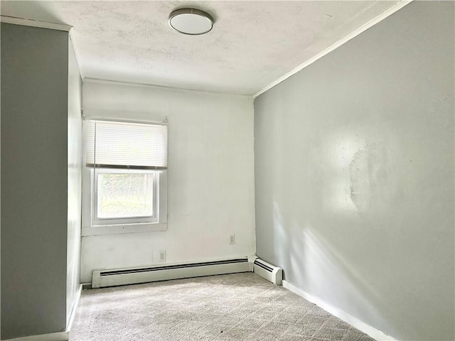 carpeted empty room featuring a baseboard heating unit, a textured ceiling, ornamental molding, and baseboards