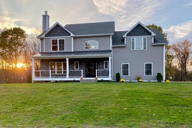 view of front of house with covered porch and a yard