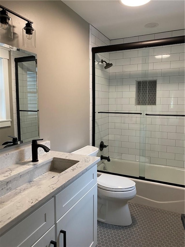 full bathroom featuring tile patterned flooring, vanity, toilet, and enclosed tub / shower combo