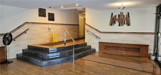 staircase featuring hardwood / wood-style flooring and tile walls